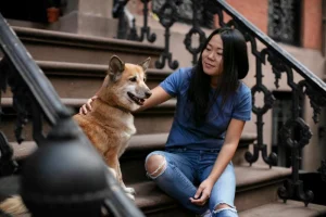 asian woman patting dog in the staricase