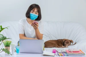 dog sleeping in the sofa while the asian woman is using mobile