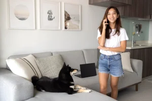 woman talking on her phone while the dog is on sofa